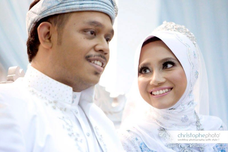 Muslim bride and groom seating on the stage and looking at each other as covered by Wedding Photographer Malaysia