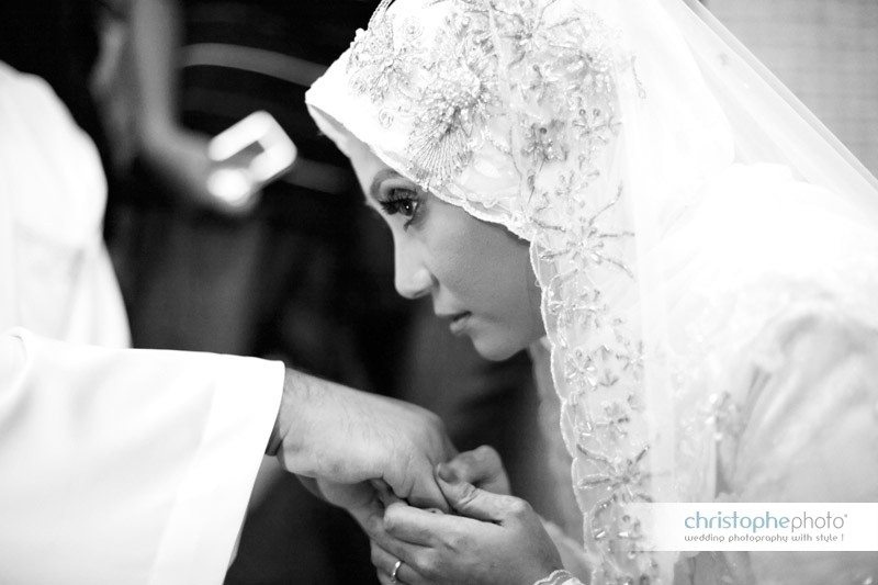 Muslim bride at the mosque for the wedding in Malaysia. She is kissing the hand of the husband in Ipoh Malaysia