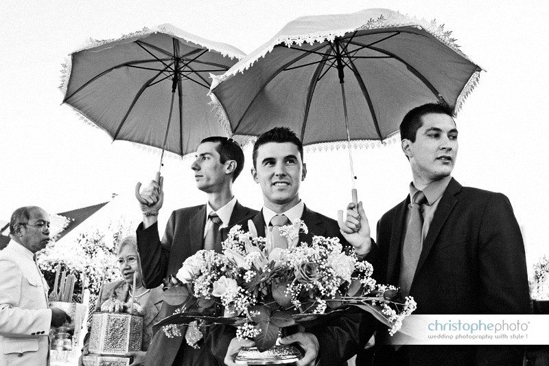 The groom making his entrance in style under the shade of the umbrellas. The procession shot by wedding photographer cambodia