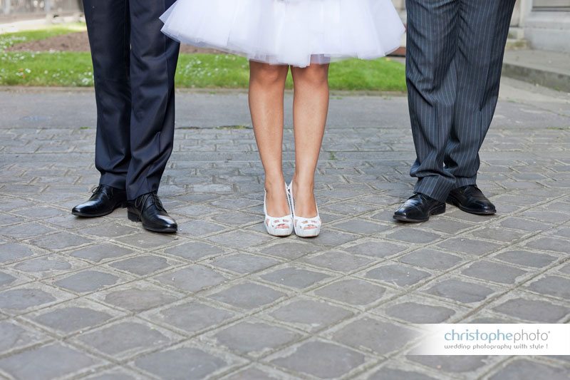The wedding dress is like a ballerina dress. The bride is sourrounded by her husband and his brother.