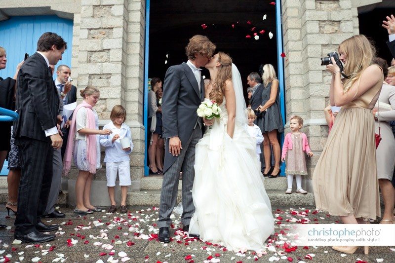 the couple is kissing in front of the church after the wedding ceremony.