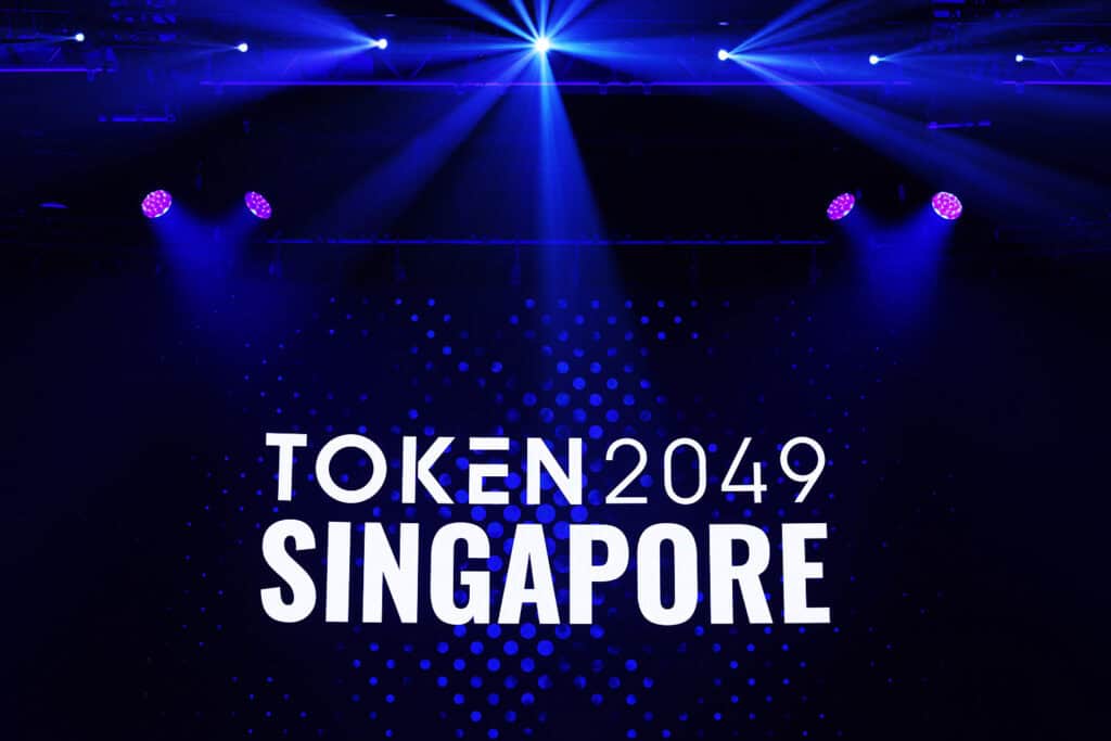 Singapore TOKEN 2049 conference stage with audience and professional lighting setup.
