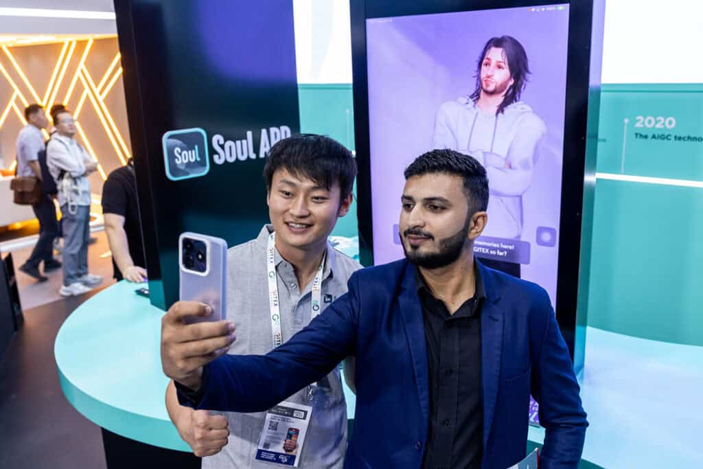 Two men are taking a selfie during a tradeshow.