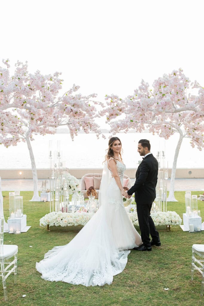 Bride and groom posing in the garden of Burj Al Arab Hotel Dubai after their outdoor wedding ceremony.